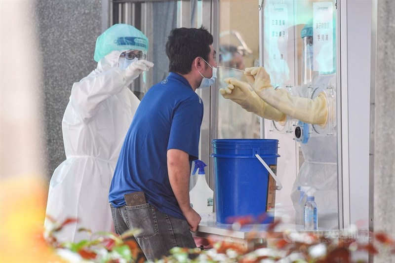 中央流行疫情指揮中心原則同意開放企業為員工快篩,但採檢須由醫事人員執行。圖為新北市中和一處篩檢站。(中央社檔案照片)