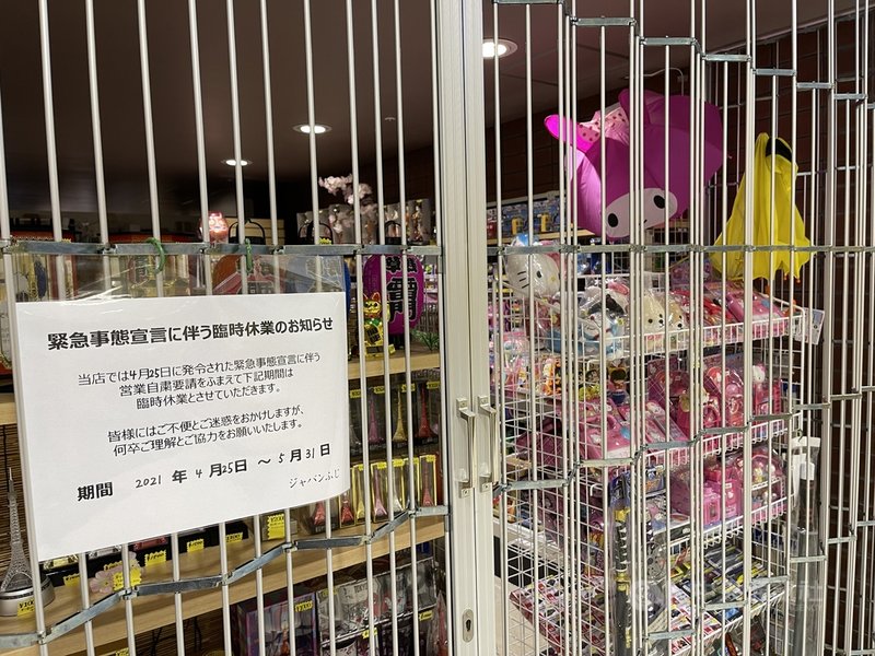 日本首相菅義偉28日宣布,目前適用緊急事態宣言的東京等10地當中的9地,實施期限由5月31日延長至6月20日。圖為東京鐵塔內商店張貼告示,說明因緊急事態宣言暫停營業。中央社記者楊明珠東京攝 110年5月29日
