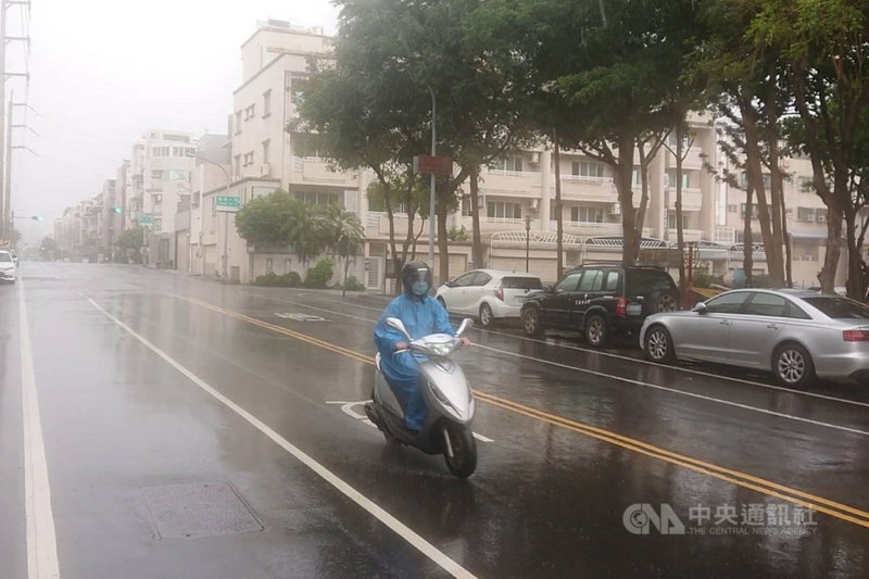 台南部分地區29日上午開始出現雨勢,平地較明顯,機車騎士也穿上雨衣。中央社記者楊思瑞攝 110年5月29日