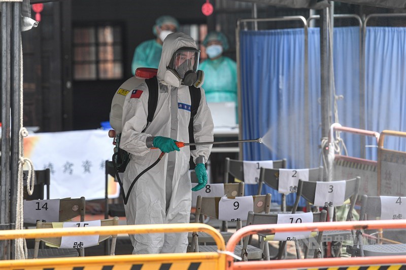 COVID-19疫情蔓延全球,台灣累計78死超越SARS。圖為國軍化學兵在萬華剝皮寮快篩站全面消毒。(中央社檔案照片)