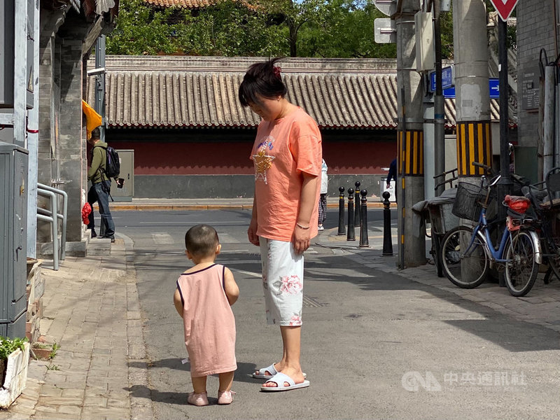 中共中央政治局會議5月31日提出實施三孩生育政策,但中國網友普遍認為「生得起、養不起」,對生育三孩持保留態度。圖為北京街頭帶著幼童的家長。中央社記者繆宗翰北京攝 110年6月1日