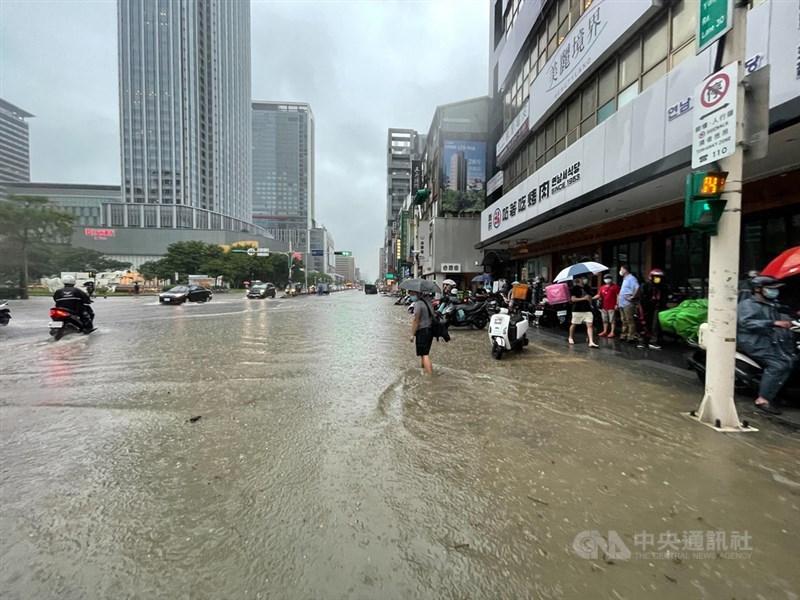 受梅雨鋒面及颱風彩雲外圍環流影響,4日中午12時起北市即開始有持續性的強對流發展,市中心有瞬間強降雨,文山、大安及信義區時雨量均超過100毫米;信義區部分路面有淹水情形,民眾將機車暫停在路邊。中央社記者張新偉攝 110年6月4日