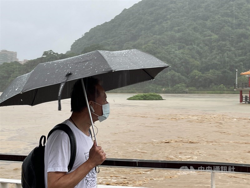 氣象局預報梅雨鋒面5日至7日將在台灣上空徘徊,週休假日降雨更明顯,西半部及東北部防大雨或豪雨。圖為4日午後大湖公園因豪雨成一片汪洋,民眾撐著傘快步通行。中央社記者王飛華攝 110年6月4日