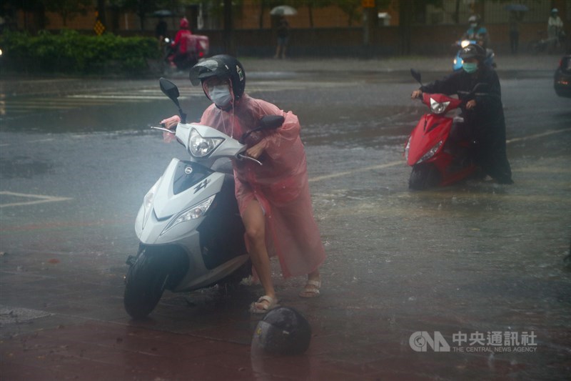 颱風彩雲外圍環流加上梅雨鋒面接近影響，台北市4日午後降豪雨，基隆路三段出現積水的情況，機車騎士在雨中推車前進。中央社記者王騰毅攝 110年6月4日