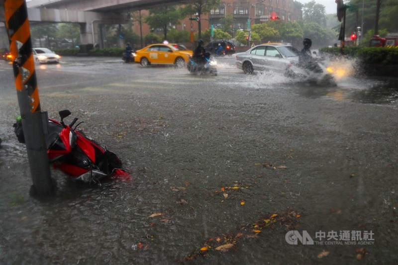 受颱風來襲影響,4日北市午後降下大雨,基隆路3段出現淹水的情況,機車騎士在雨中奔馳,激起水花。中央社記者王騰毅攝 110年6月4日