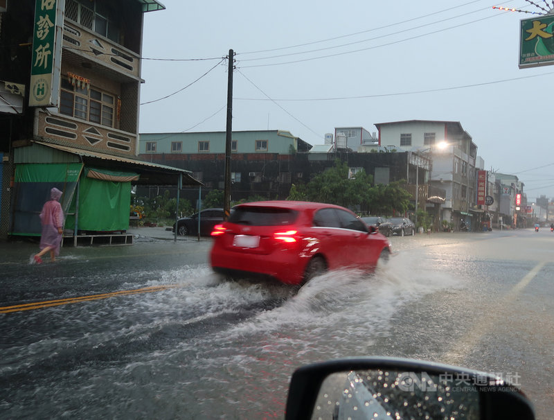 高雄市豪雨不斷,岡山區嘉興路一帶6日清晨積淹水約半個輪胎深,造成人車通行不便。中央社記者王淑芬攝 110年6月6日