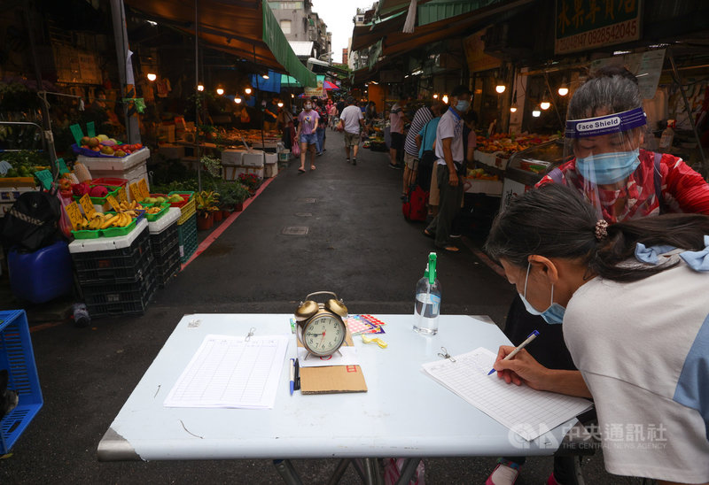 國內COVID-19疫情嚴峻,配合相關防疫工作,民眾在進入傳統市場前要掃QR Code完成實聯制,或手寫留下聯絡資料等。中央社記者謝佳璋攝 110年6月6日