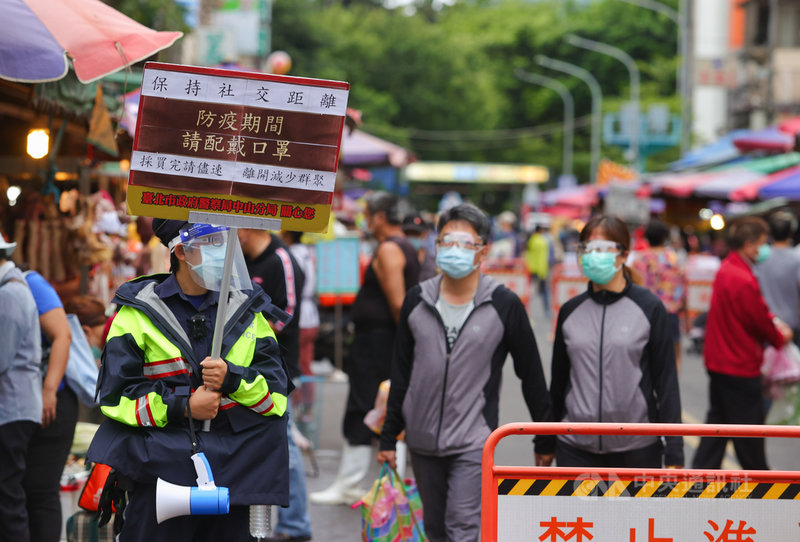 國內COVID-19疫情嚴峻,政府呼籲民眾減少採買次數避免群聚,台北市警方6日在傳統市場舉牌宣導,提醒民眾戴口罩、保持社交距離,採購完畢減少逗留、儘速離開。中央社記者謝佳璋攝 110年6月6日