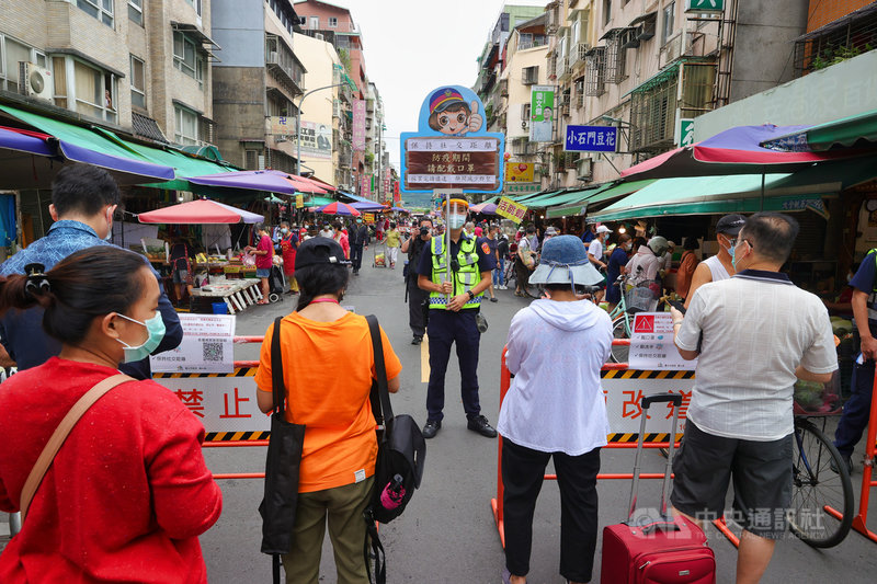國內COVID-19疫情嚴峻,政府呼籲民眾減少採買次數避免群聚,台北市警方6日在傳統市場入口處管制並進行相關宣導。中央社記者謝佳璋攝 110年6月6日
