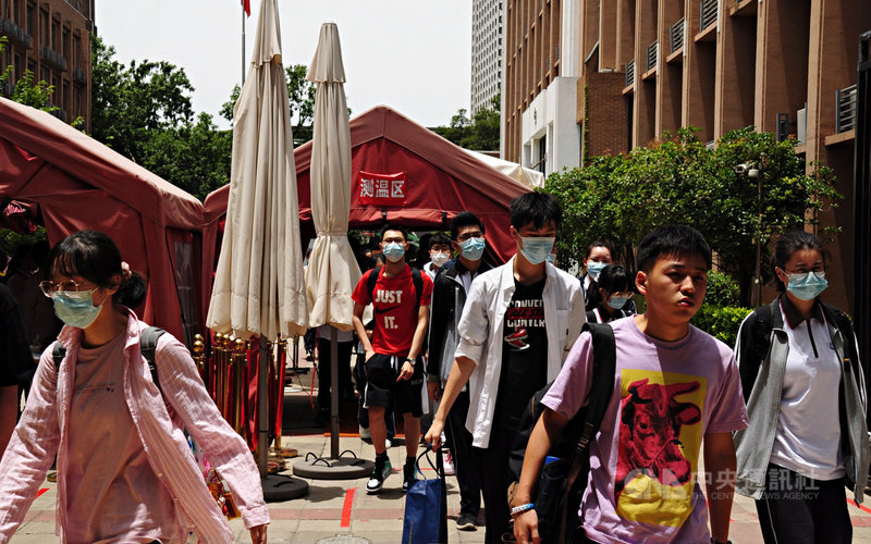 中國2021年高考(類似大學指考)在2019冠狀病毒疾病(COVID-19)陰霾下登場,許多省市要求考生應試前須先接受病毒核酸檢測,進入考場前也需量體溫。圖為上海一處考場考生經過測溫點。中央社記者沈朋達上海攝 110年6月7日