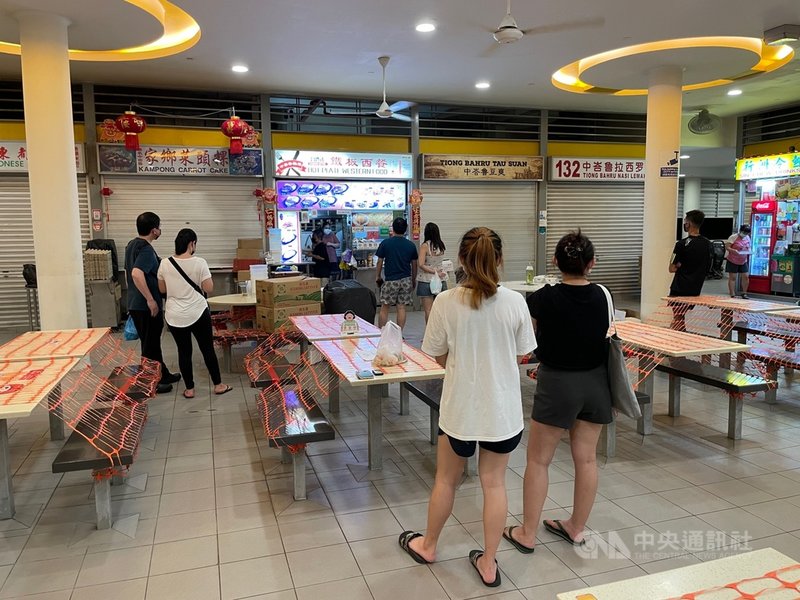 新加坡防疫升級,禁止餐廳及小販中心內用,圖為民眾在中峇魯熟食中心一家攤販外帶餐點。攝於5月22日。中央社記者侯姿瑩新加坡攝 110年6月8日