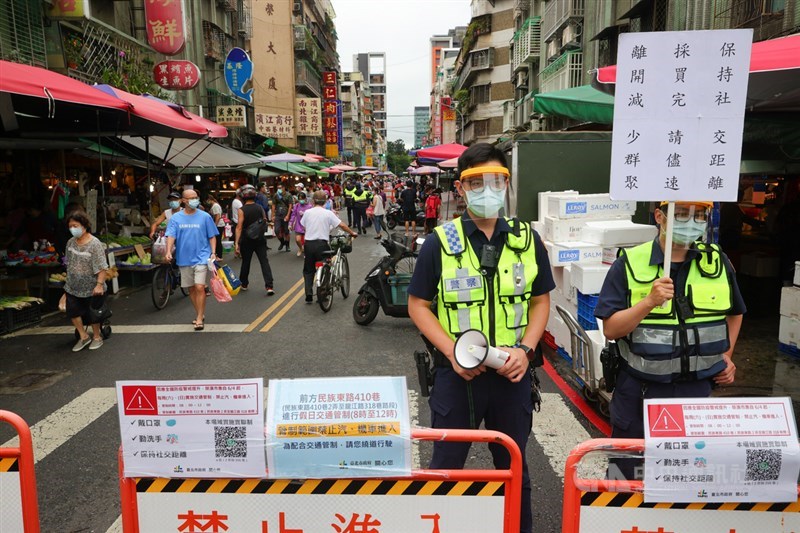 國內COVID-19疫情嚴峻,台北市警方6日在傳統市場舉牌宣導,呼籲民眾保持社交距離、減少群聚。中央社記者謝佳璋攝 110年6月6日
