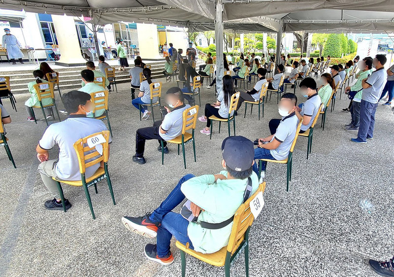 為防堵疫情,高雄市政府9日啟用路竹、楠梓、前鎮科學園區快篩站,針對企業移工進行快篩,市府10日再進一步宣布,11日將新增大發工業區及臨海工業區篩檢站。圖為楠梓科技產業園區篩檢站移工10日依序就座、等待採檢。中央社記者董俊志攝 110年6月10日
