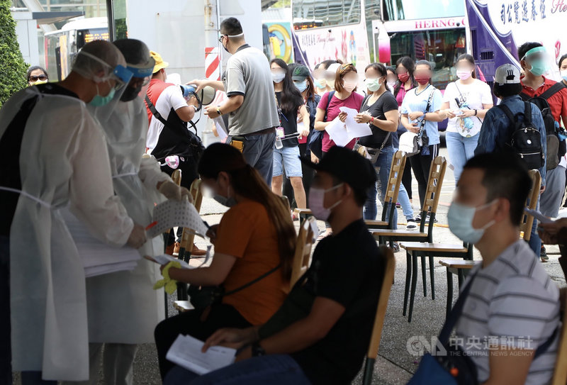 高雄市長陳其邁10日表示,9日已啟用路竹科技園區、楠梓科技產業園區、前鎮加工出口區篩檢站,預計快篩1萬380人,目前檢查都正常。圖為楠梓科技產業園區移工們排隊等候採檢。中央社記者董俊志攝 110年6月10日