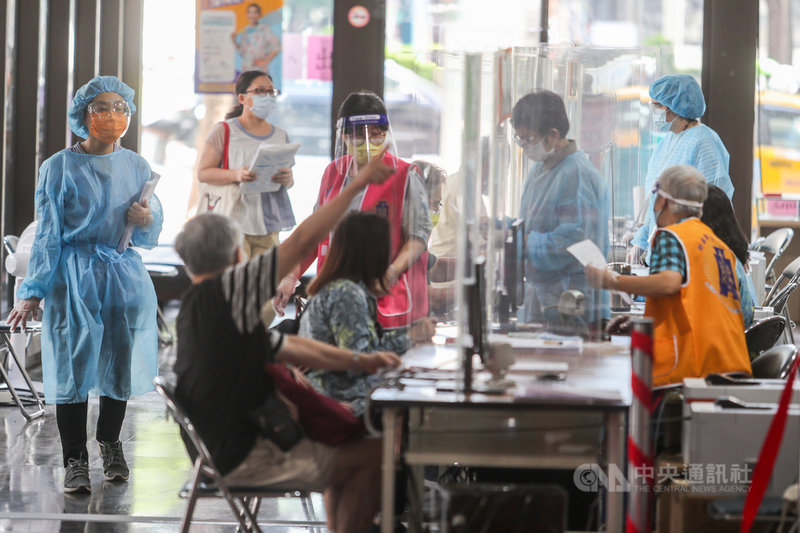 國稅局15日恢復臨櫃報稅服務,第一線工作人員穿著隔離衣帽、面罩、手套等防護裝備,在櫃檯設置隔板並拉開座位距離,落實防疫措施。中央社記者裴禛攝 110年6月15日