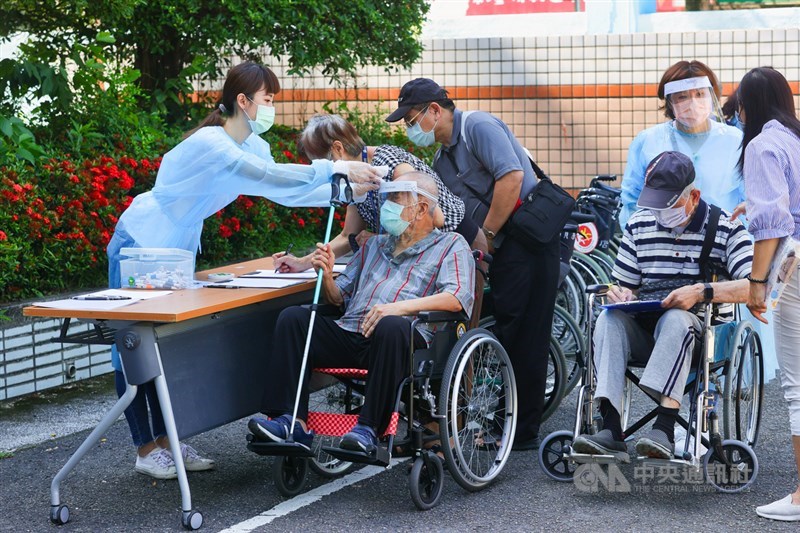 台北市民眾15日在信義國中社區接種站排隊量體溫準備接種。中央社記者謝佳璋攝 110年6月15日