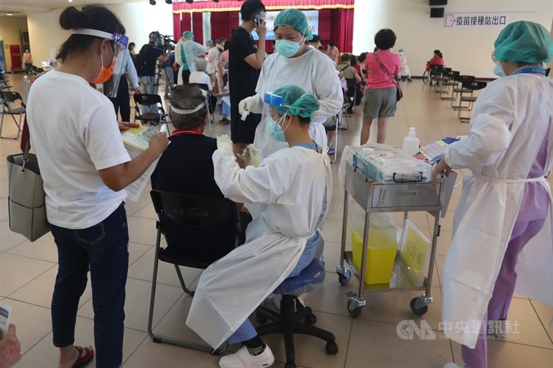 新北市15日針對85歲以上長者施打AZ疫苗，三重體育館接種區採用「宇美町式」接種法，讓長者依序排排坐，由醫護滑動逐一施打，減少長輩移動的風險。中央社記者王騰毅攝 110年6月15日