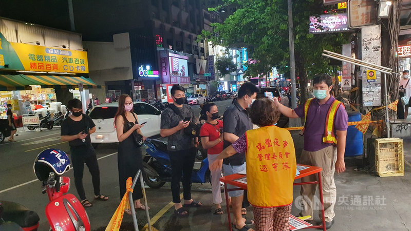 武漢肺炎本土疫情仍持續,高雄瑞豐夜市15日下午起恢復營業,市府經發局聯合警方派員到場督導落實防疫措施,現場工作人員在出入口處為民眾量測體溫、確認實聯制資訊等。中央社記者洪學廣攝 110年6月15日