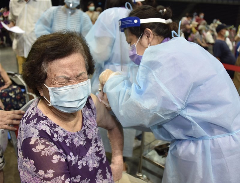 高雄市高齡長輩疫苗接種15日啟動,首波是87歲以上長者,漢神巨蛋體育館等56站同步施打,醫護採「宇美町式」讓長輩排排坐好,由醫護移動來注射疫苗。中央社記者董俊志攝 110年6月15日