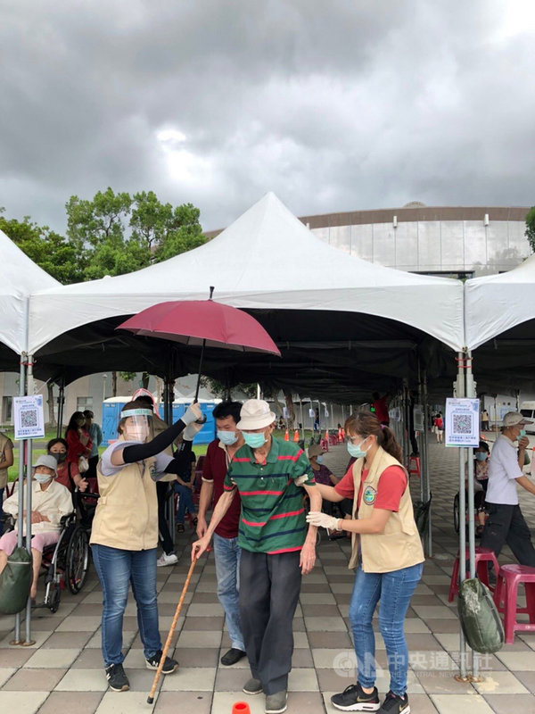 屏東縣85歲以上長者15日展開武漢肺炎疫苗接種,過程順利。縣長潘孟安表示,他看到一幕非常感動,就是社工員在下車處,為長者撐傘,耐心攙扶長者,提供協助。(屏東縣政府提供)中央社記者郭芷瑄傳真 110年6月15日