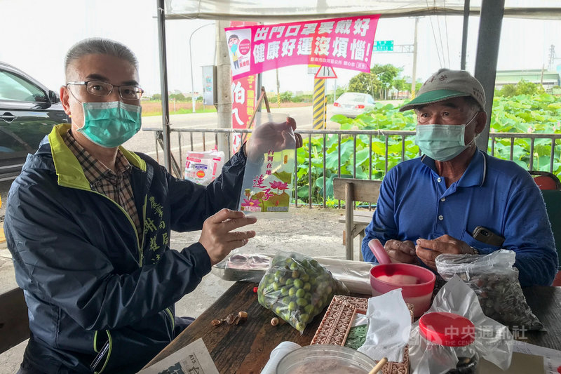 台南市白河區生產的蓮子進入採收期,市府農業局長謝耀清(左)推薦消費者選購使用印有「白河在地蓮子」及蓮農資訊的包裝袋。(台南市農業局提供)中央社記者楊思瑞台南傳真 110年6月16日