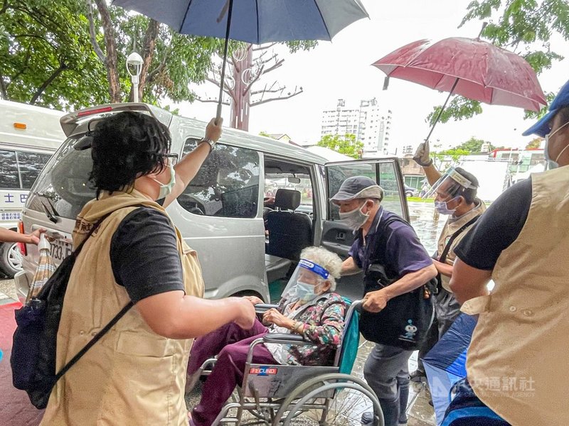 武漢肺炎疫苗大規模施打進入第3天,前2天屏東下雷陣雨,注射站屢見社工、警察為長輩撐傘貼心服務,不少社工只遮長輩,自己淋濕,縣長潘孟安臉書發文感謝。(取自潘孟安臉書)中央社記者郭芷瑄傳真 110年6月17日
