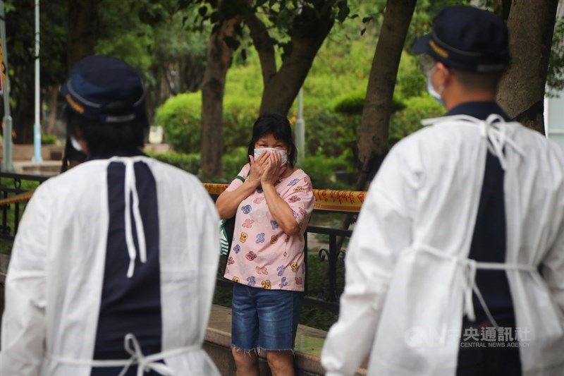 國內疫情持續,三級警戒期限僅剩11天,外界好奇警戒是否3度延長,指揮中心僅表示,持續關注疫情變化。圖為民眾見到警察趕緊確認口罩是否確實戴好。(中央社檔案照片)
