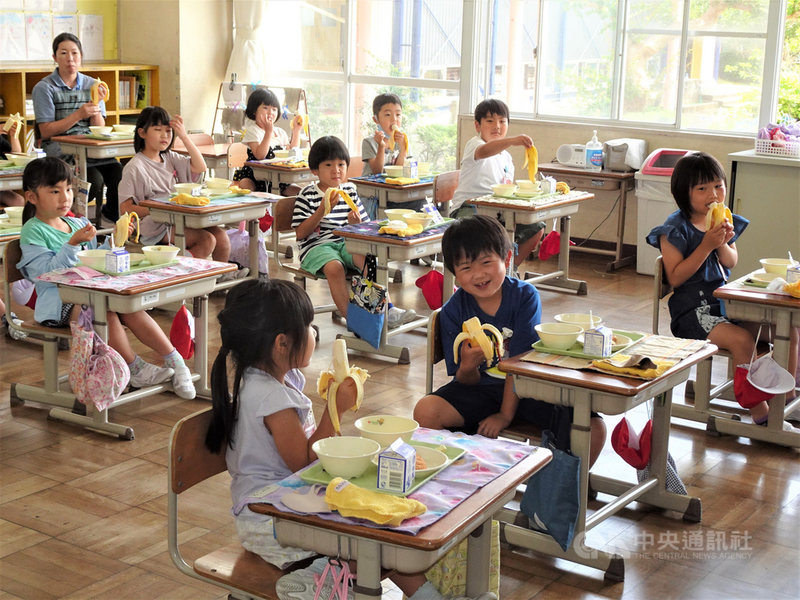 駐日代表謝長廷18日中午造訪東京奧運台灣隊接待城茨城縣笠間市,贈香蕉給當地學童,學童們吃得津津有味。中央社記者楊明珠茨城攝 110年6月18日