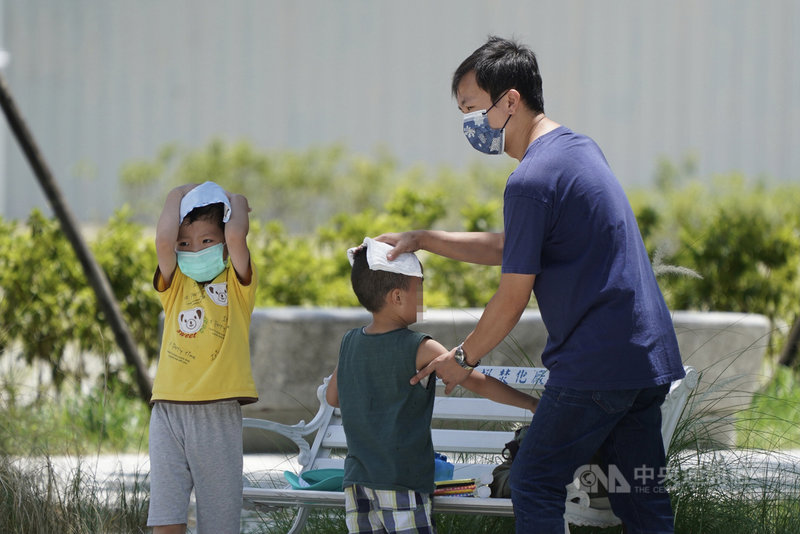 西南風沉降影響,中央氣象局18日上午發布10縣市高溫燈號,台北市、新北市、台東縣地區為橙色燈號,有連續出現攝氏36度高溫的機率。家長帶孩子出外運動後,幫他們擦汗。中央社記者徐肇昌攝 110年6月18日