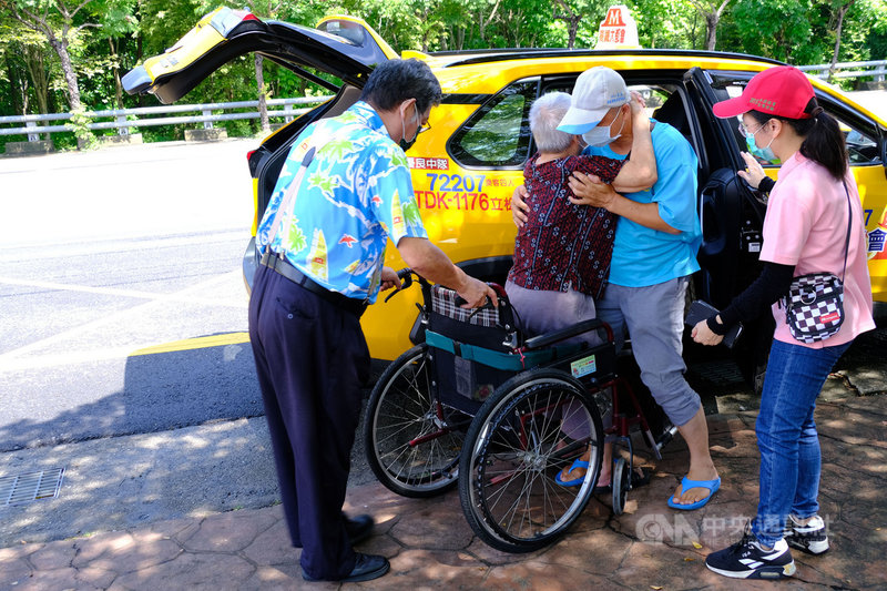 高雄市推出「熱血計程車」載送長者打疫苗，一早前往燕巢活動中心幫忙載客的石姓司機是「拚命三郎」，且貼心幫行動不便長者推輪椅協助上車。中央社記者洪學廣攝　110年6月20日