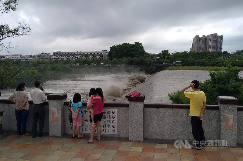 嘉義山區20日上午降下大雨,八掌溪水暴漲,流至道將圳攔河堰形成百米長瀑布景觀,有民眾冒雨前往欣賞。中央社記者蔡智明攝 110年6月20日