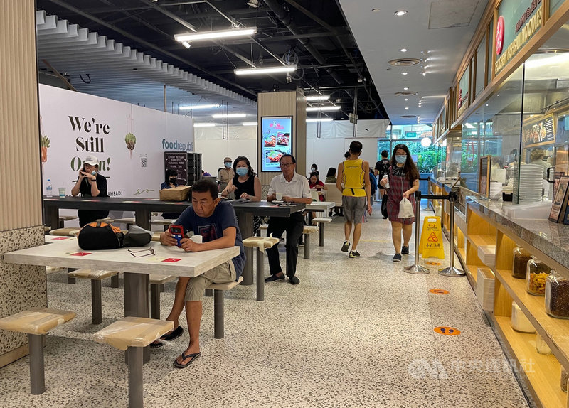 新加坡疫情趨穩,21日起恢復開放餐廳內用,但最多只能2人一組。圖為當地一家商場內的美食街。中央社記者侯姿瑩新加坡攝 110年6月21日