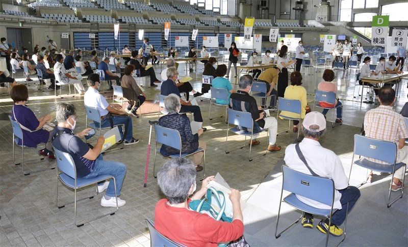 日本東京都等地「緊急事態宣言」20日結束,沖繩縣因為疫情暫未趨緩,成日本唯一實施緊急事態宣言的地區。圖為沖繩疫苗施打中心等待接種的老年人。(共同社)