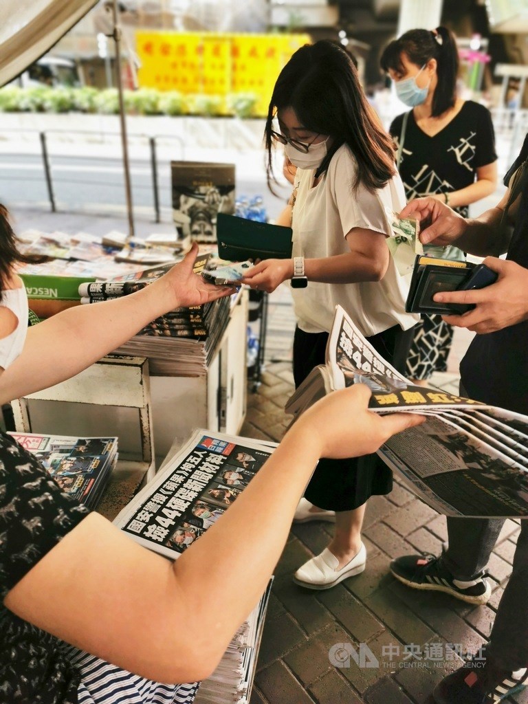 香港蘋果日報員工收到內部信指出,公司資金如果未獲解凍,25日將出版最後一份報紙。圖為香港蘋果5位高層被拘捕後18日加印50萬份,大批市民一早購報以示支持。(中央社檔案照片)