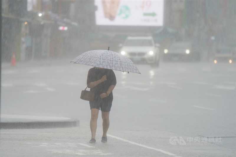 受滯留鋒面及西南風影響，大台北地區22日午後下起滂沱大雨，街頭民眾雨中撐傘低頭前進。中央社記者徐肇昌攝 110年6月22日