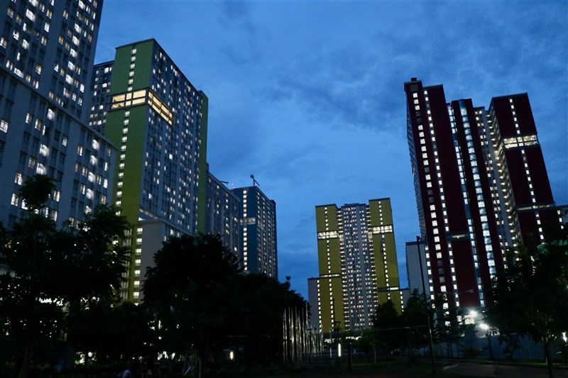 印尼疫情創新高峰,雅加達的病床9成已滿,印尼政府將加緊提供病床。亞運選手村改建的COVID-19患者專責醫院收治超過6000名患者,21日晚間通火通明。中央社記者石秀娟雅加達攝 110年6月21日
