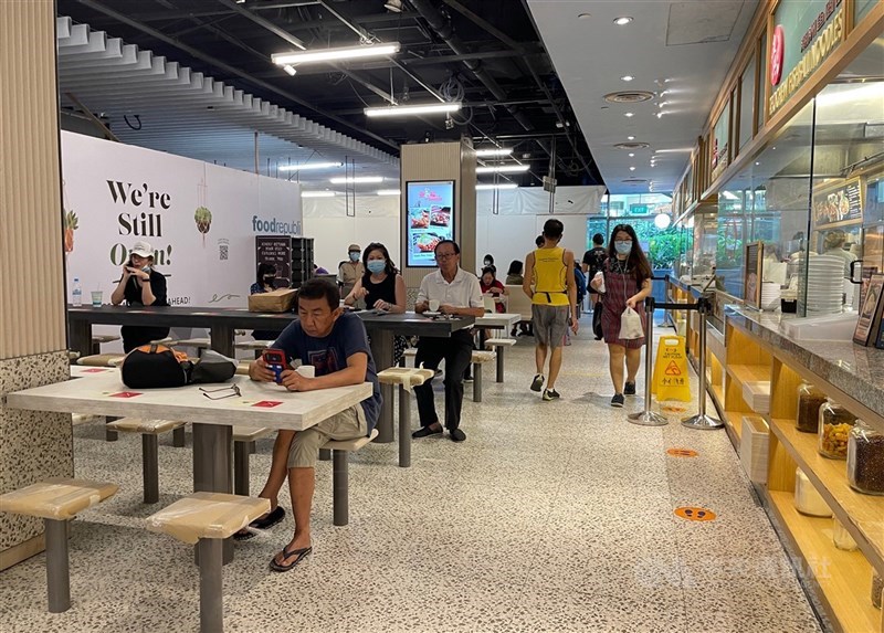 新加坡疫情趨穩,21日起恢復開放餐廳內用,但最多只能2人一組。圖為當地一家商場內的美食街。中央社記者侯姿瑩新加坡攝 110年6月21日