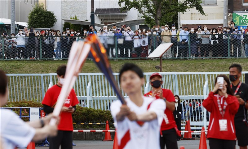 國際奧會與日本政府決定東奧開放現場觀眾最多一萬人，若疫情升溫改閉門。圖為21日聖火傳遞至宮城縣仙台市，許多民眾在場外圍觀。（共同社）