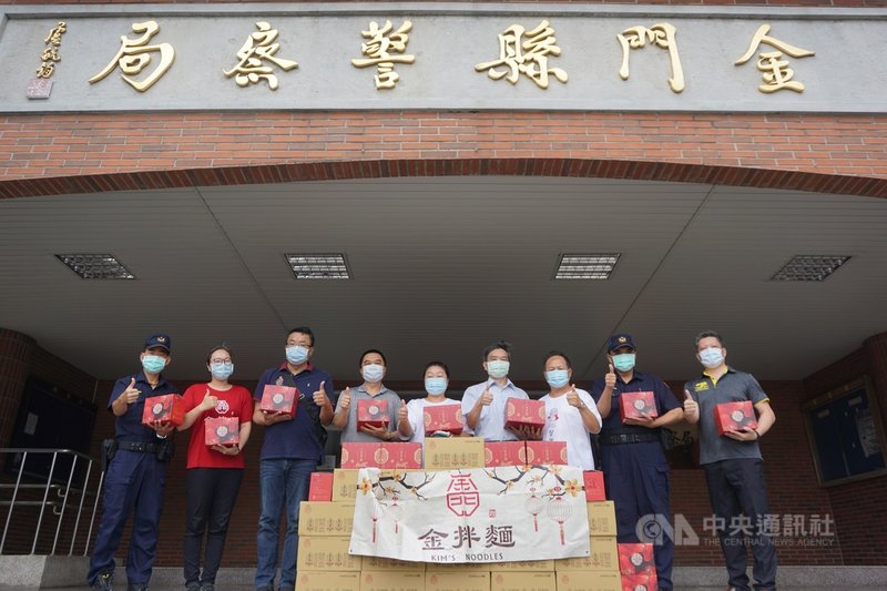 武漢肺炎(2019冠狀病毒疾病,COVID-19)疫情持續,為感謝第一線防疫人員的辛苦,莉豐建設公司董事長張莉(中)和金拌麵董事長崔文柏(右3)25日聯合捐贈拌麵和燕仔草茶給金門縣警察局,由局長蔡祥春(右4)等人接受。中央社記者黃慧敏攝 110年6月25日