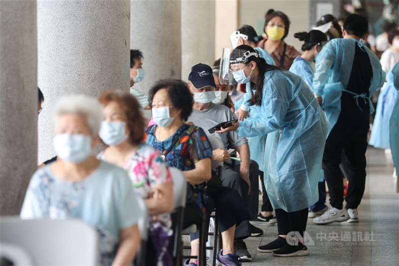 台灣24日新增129例COVID-19本土個案,另新增6人染疫死亡。疫情指揮中心指揮官陳時中說,雖然連2天案例數微幅上升,但整體疫情趨勢持續下降。圖為民眾在信義國中接種站排隊施打疫苗。中央社記者裴禛攝 110年6月24日