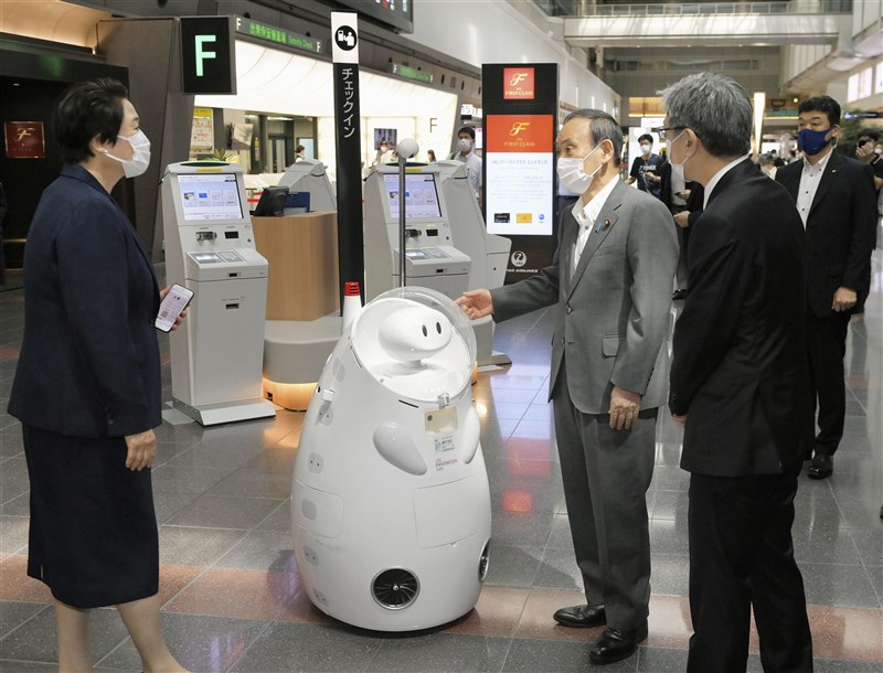 東京奧運即將開幕,日本首相菅義偉(中)28日視察東京羽田機場,指示徹底做好入境管理與防疫措施。(共同社)