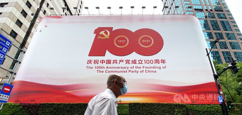 中共百年黨慶將於7月1日到來。圖為一名民眾途經上海黃浦區慶祝黨慶的巨型看板。中央社記者沈朋達上海攝 110年6月29日