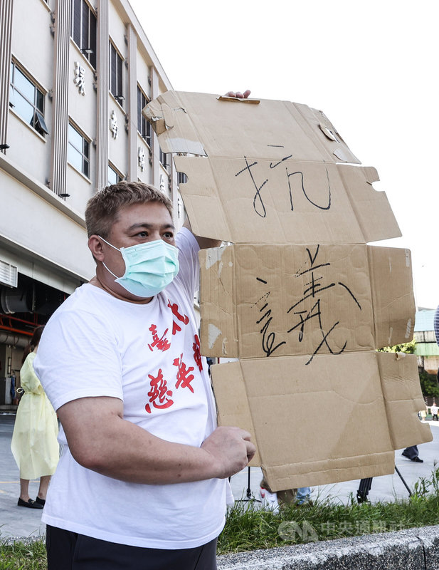 台北市政府針對環南市場從業人員進行PCR篩檢,發現有41名攤商PCR陽性,要求休市3天、清消場域。2日上午有攤商拿出手寫紙板抗議緊急休市。中央社記者鄭清元攝 110年7月2日