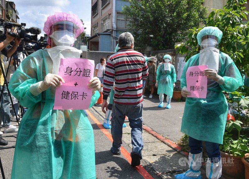 台北市虎林街、永春市場一帶發生武漢肺炎疫情,北市府4日啟動「虎林專案」,在永吉國小設置篩檢站,工作人員提醒採檢民眾出示健保卡與身分證。中央社記者王飛華攝 110年7月4日