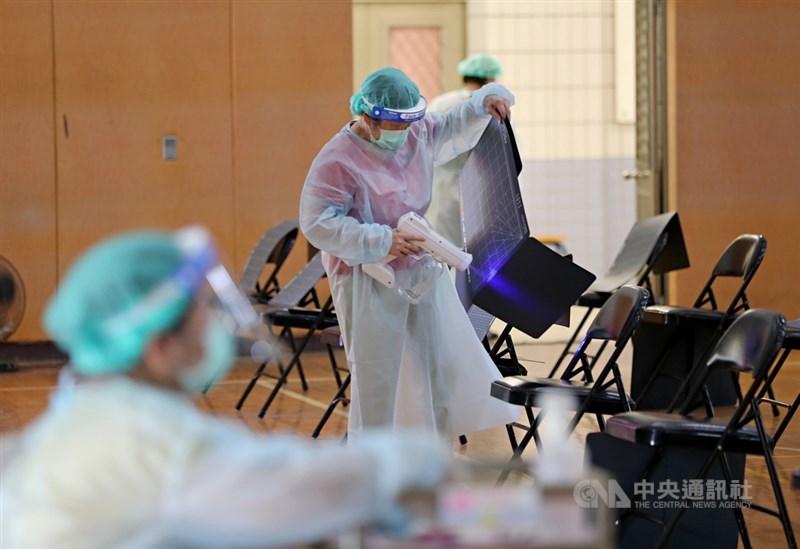 指揮中心公布國內新增28例本土病例及3例境外移入,另新增1例死亡。圖為醫護人員清潔座位區,用消毒噴槍清潔民眾使用過的墊板。中央社記者裴禛攝 110年7月5日