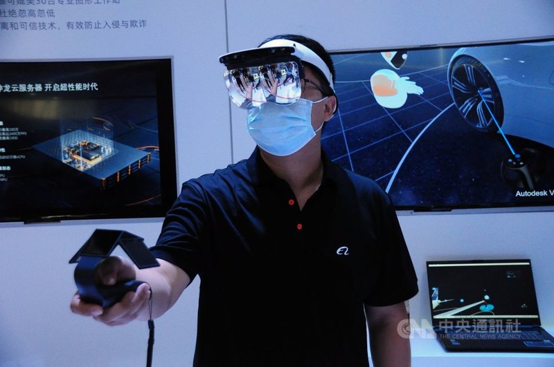 一名「阿里雲」員工示範用頭部顯示儀,進行虛擬實境操作。中央社記者沈朋達上海攝 110年7月8日