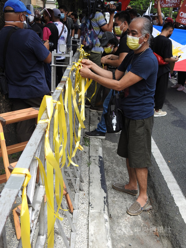 菲中南海爭議仲裁結果出爐屆滿5周年。多個菲律賓民間團體12日號召數百名支持者前往中國大使館前示威,繫黃絲帶緬懷前總統艾奎諾三世,並呼籲北京當局尊重南海裁決。中央社記者陳妍君馬尼拉攝 110年7月12日