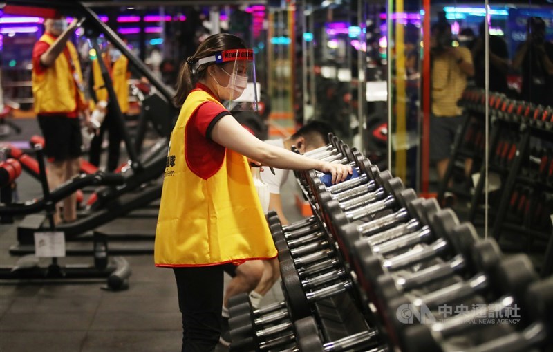 World Gym世界健身俱樂部工作人員配戴口罩、護目鏡,仔細為器材消毒。中央社記者張新偉攝 110年7月13日