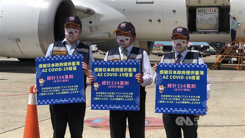 日本贈台第3批約97萬劑AZ疫苗15日下午運抵桃園國際機場,中央流行疫情指揮中心指揮官陳時中(中)率隊接機,並持中、日文標語感謝日本。中央社記者吳睿騏桃園機場攝 110年7月15日