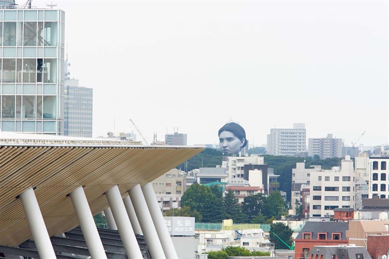 日本東京都上空16日出現一個巨大人頭熱氣球,引起民眾圍觀,形容宛如恐怖漫畫大師伊藤潤二的作品「人頭氣球」;其實這是東京奧運的現代藝術活動。(圖取自twitter.com/TTF_official_PR)